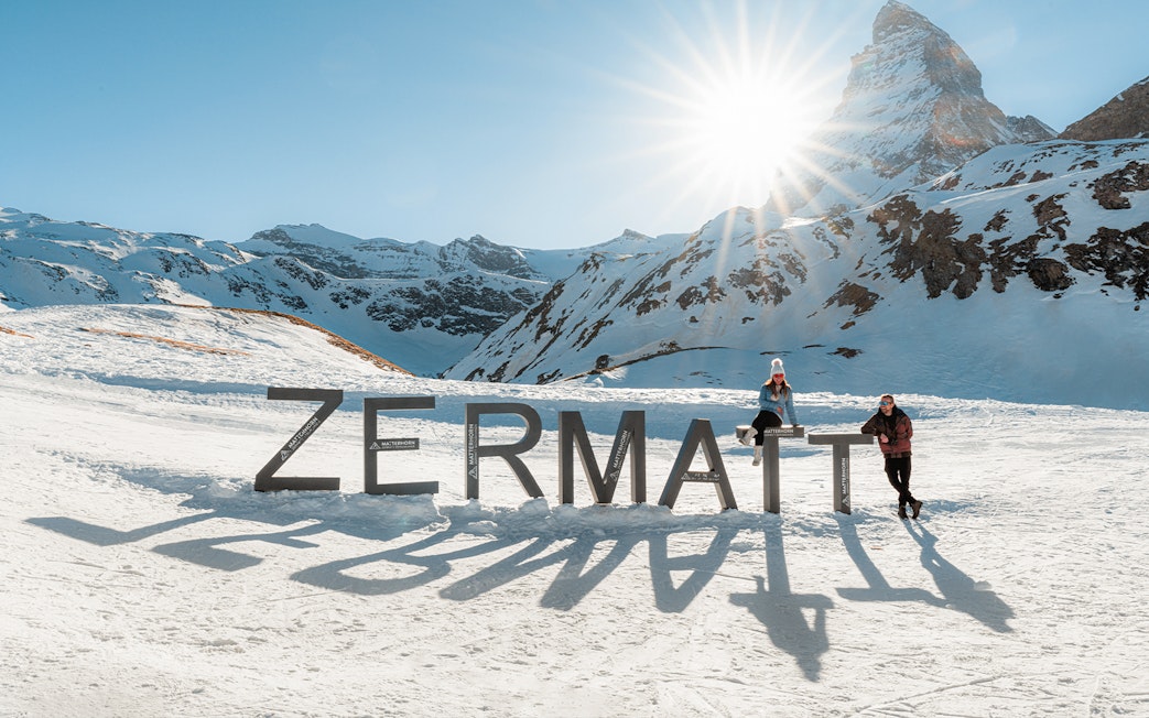 Tourists at Zermatt mountain top with Matterhorn in background.