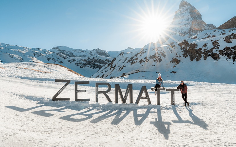 Tourists at Zermatt mountain top with Matterhorn in background.