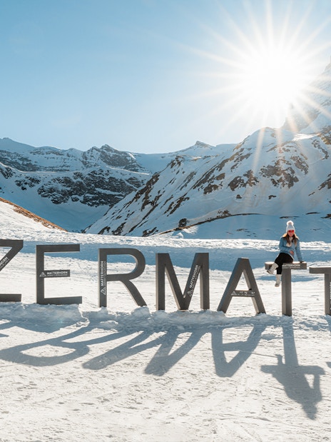 Tourists at Zermatt mountain top with Matterhorn in background.