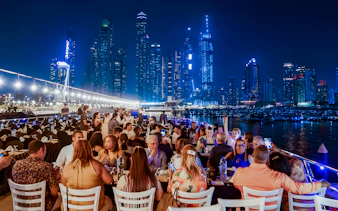 Dining on a luxury dhow cruise with city skyline views, Dubai.
