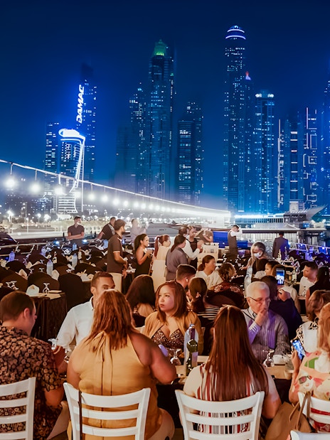 Dining on a luxury dhow cruise with city skyline views, Dubai.