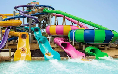 Water slides at Hurricane Harbor Chicago with people splashing into the pool.