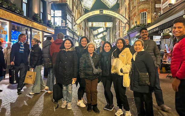 Group of people on Carnaby Street under Christmas lights during London Black Cab Tour.
