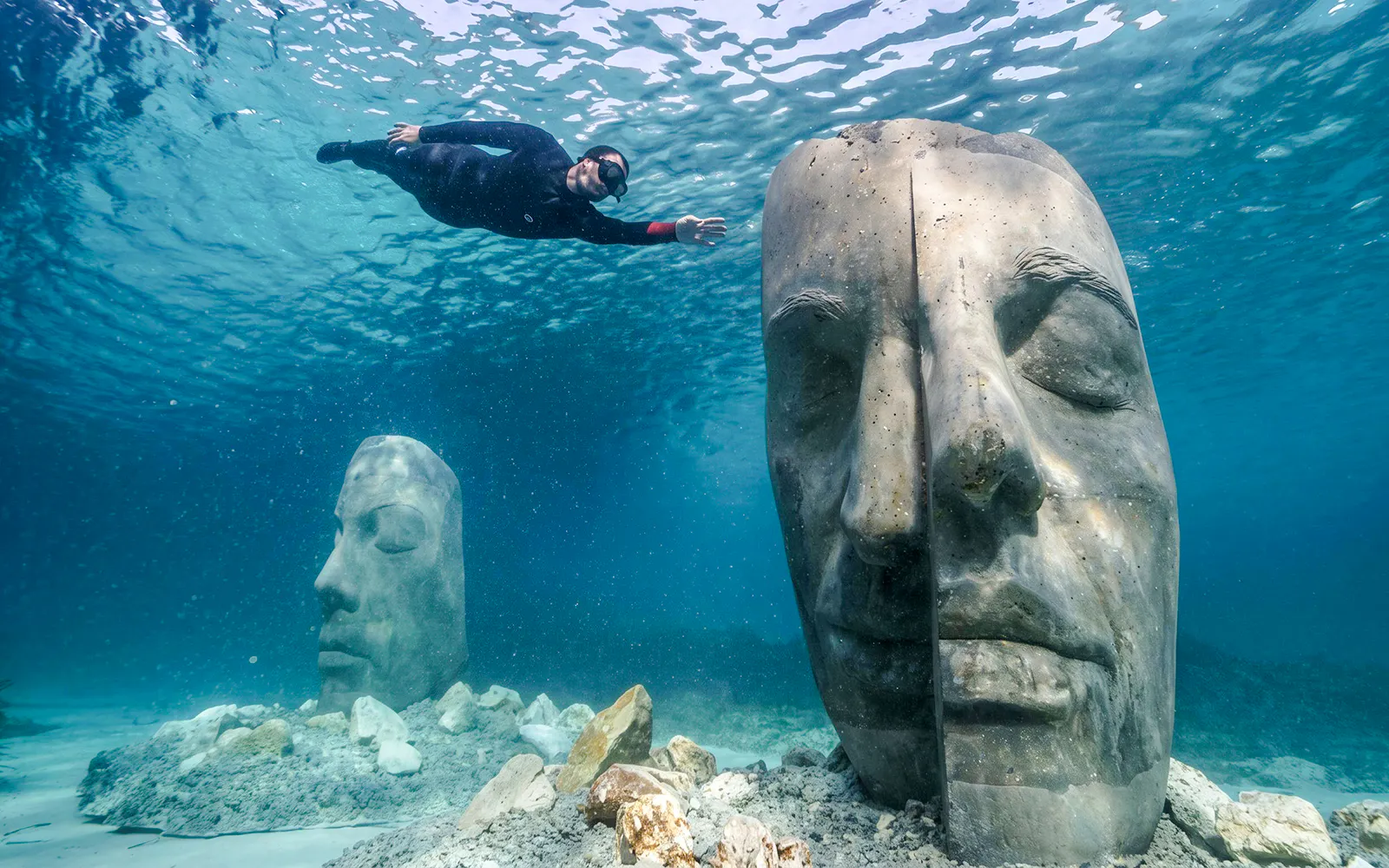 Snorkeler exploring underwater sculptures near Villefranche and Mala cove.
