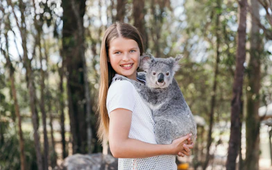 Child holding a koala at Paradise Country, Australia.