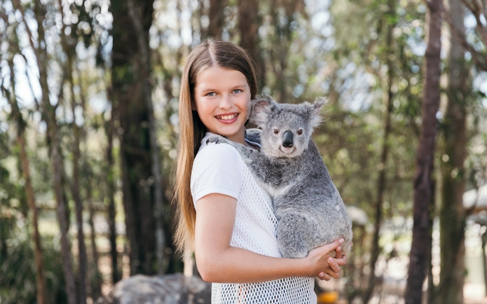 Child holding a koala at Paradise Country, Australia.