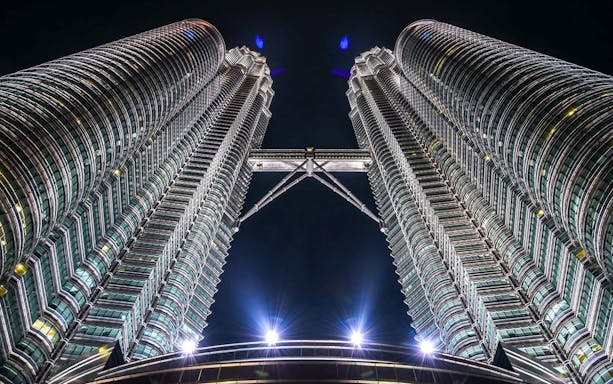 Petronas Twin Towers view from base, Kuala Lumpur, night sky backdrop.