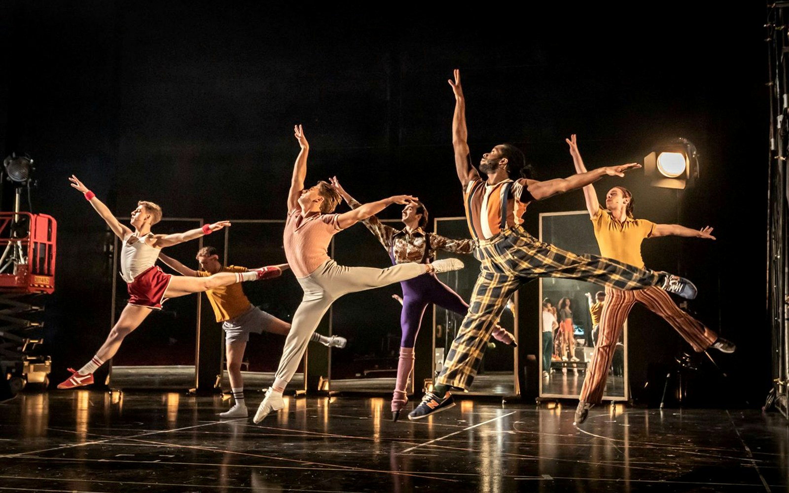 Dancers performing a high-energy routine in "A Chorus Line" on stage.