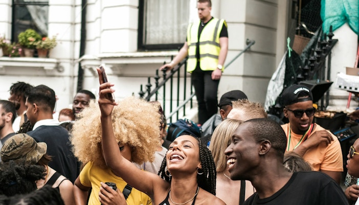 Crowd enjoying the Parade, people smiling and taking photos.