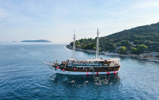 Boat party at Blue Lagoon near Split, Croatia with people swimming and enjoying the sea.
