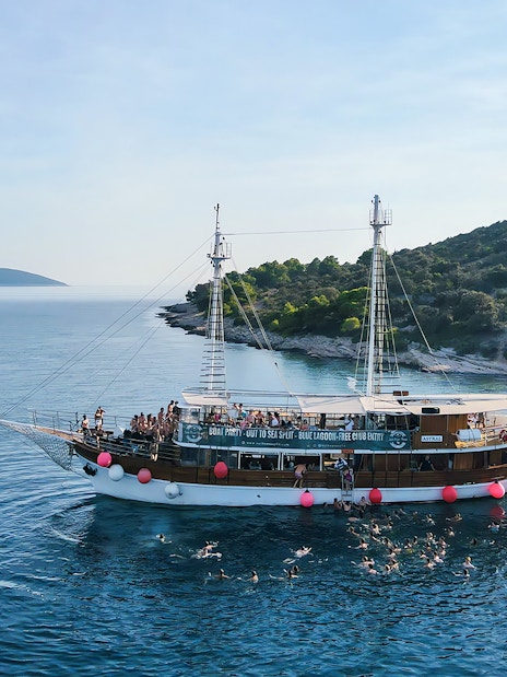 Boat party at Blue Lagoon near Split, Croatia with people swimming and enjoying the sea.