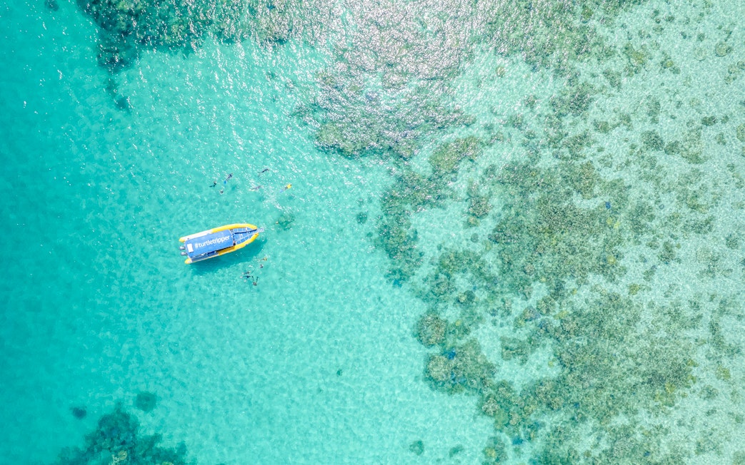 Aerial view of snorkelers near a boat on the Great Barrier Reef tour.