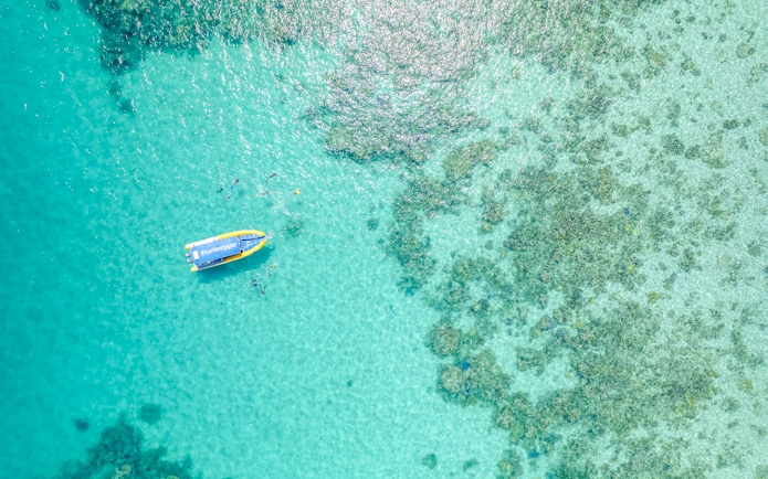Aerial view of snorkelers near a boat on the Great Barrier Reef tour.