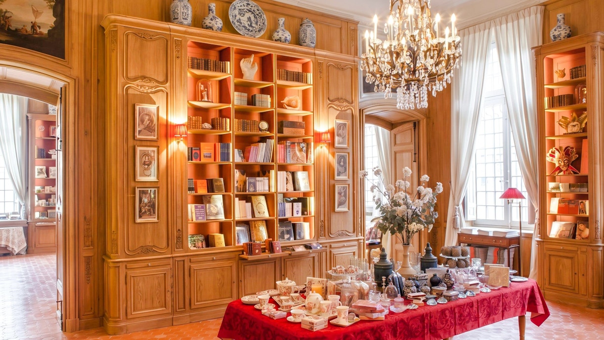 Elegant interior of Caumont Centre d’Art with bookshelves and a table set for tea.