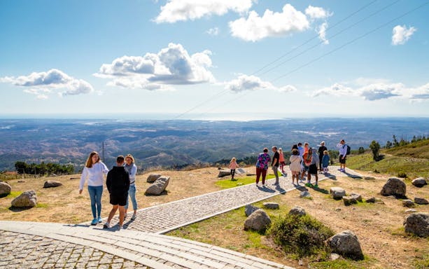 Tourists enjoying a scenic view in Algarve, Portugal.