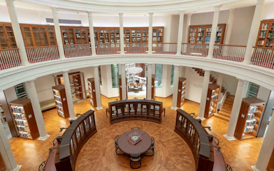 Library interior with bookshelves and reading table, National Gallery Singapore.