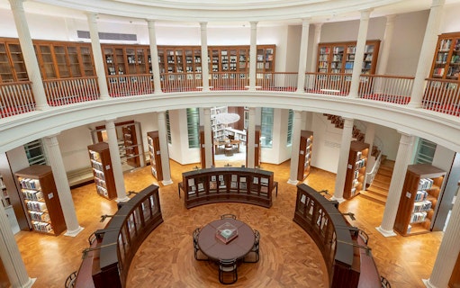 Library interior with bookshelves and reading table, National Gallery Singapore.