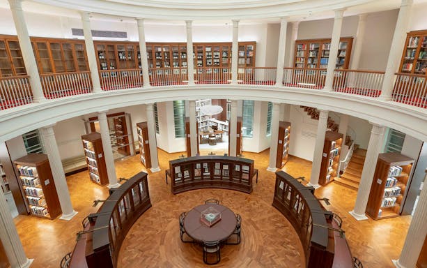 Library interior with bookshelves and reading table, National Gallery Singapore.