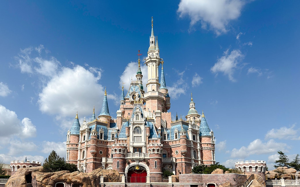 Enchanted Storybook Castle at Shanghai Disney Resort under a blue sky.