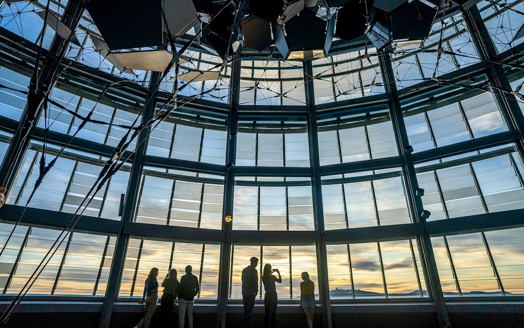 People enjoying the view from Mirador Torre Glòries, Barcelona at sunset.