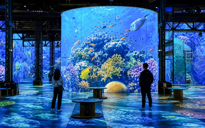 Atelier des Lumières Planète Océan exhibition with digital ocean scenes and visitors.
