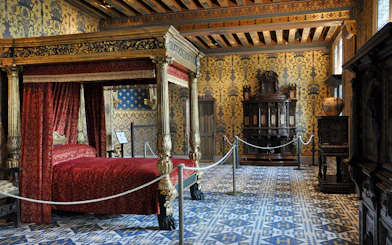 Ornate bedroom with canopy bed in Château de Blois, France.
