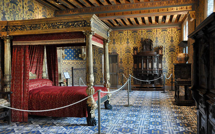 Ornate bedroom with canopy bed in Château de Blois, France.