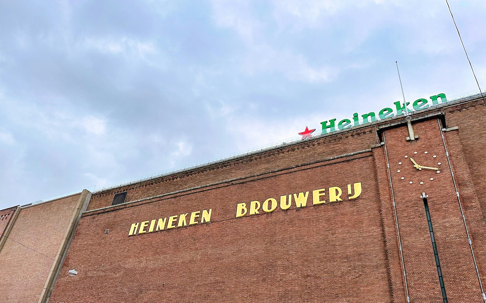 Heineken Brewery building exterior with clock in Amsterdam.