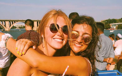 Partygoers enjoying a yacht cruise on the Potomac River with views of Washington, DC bridge.