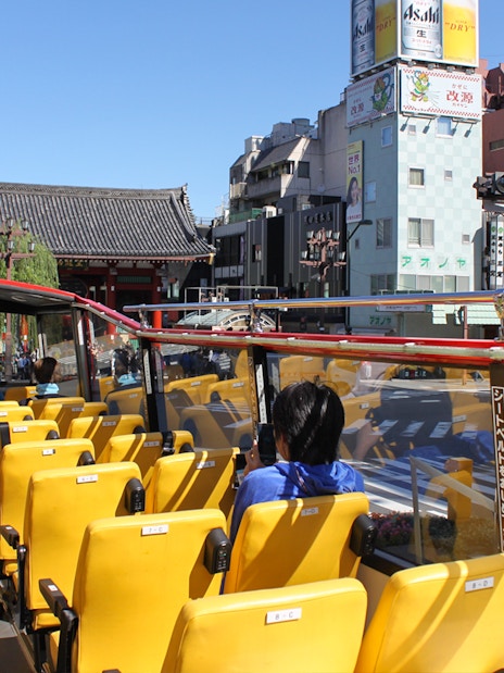 Tourists on Sky Hop bus passing through Asakusa, Tokyo with Senso-ji Temple in view.