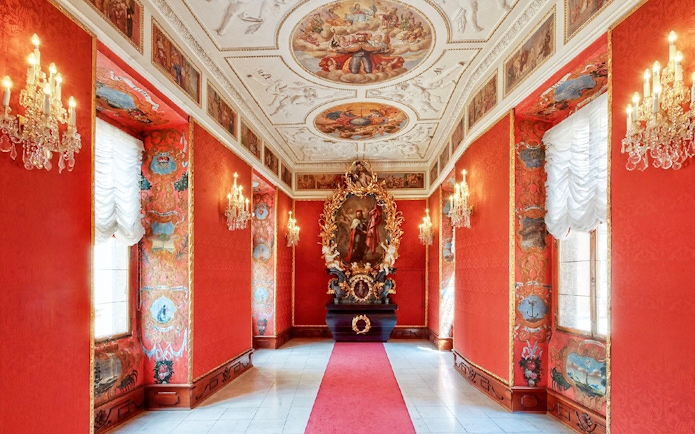 Lobkowicz Palace Museum interior with ornate red walls and historical paintings, Prague audio guide tour.