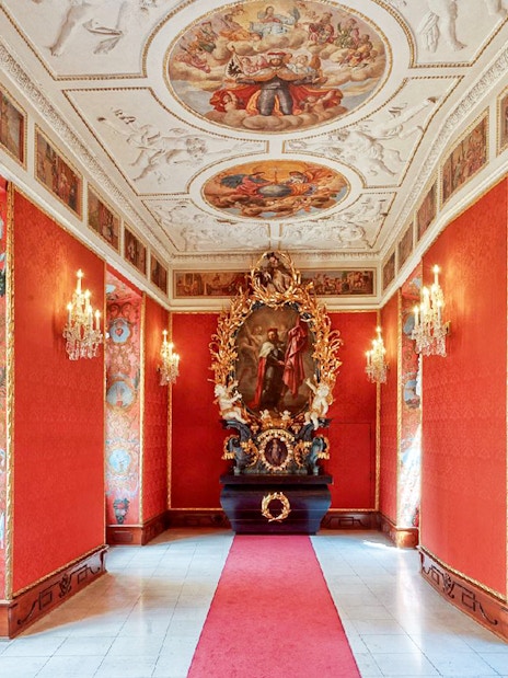 Lobkowicz Palace Museum interior with ornate red walls and historical paintings, Prague audio guide tour.