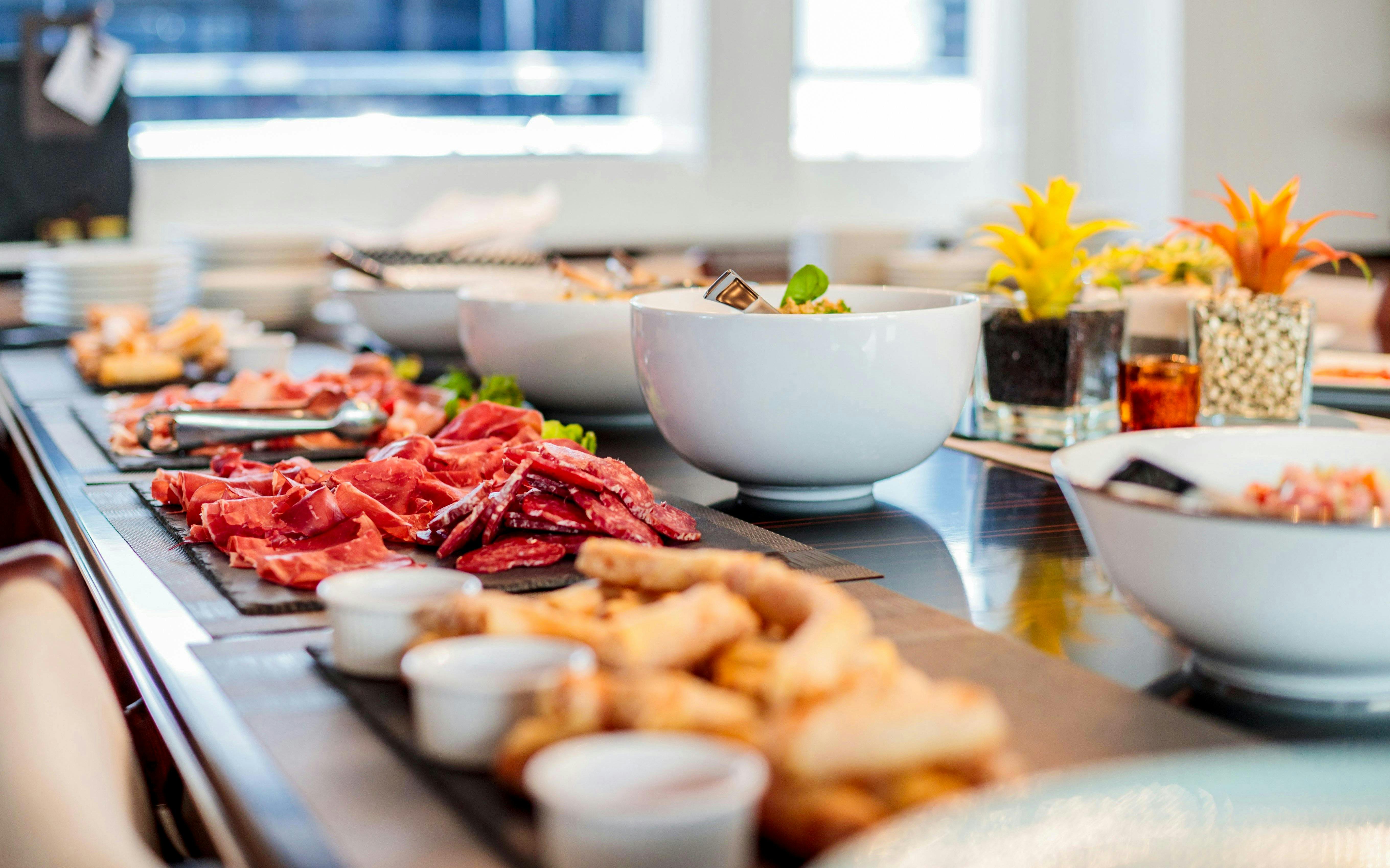 Buffet spread with meats and salads on a cruise ship dining table.