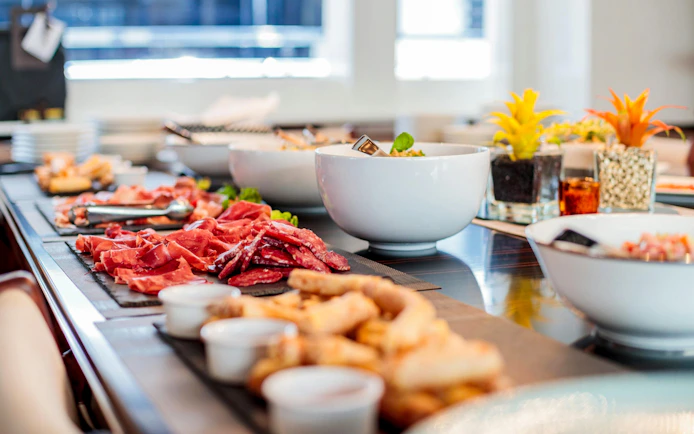 Buffet spread with meats and salads on a cruise ship dining table.
