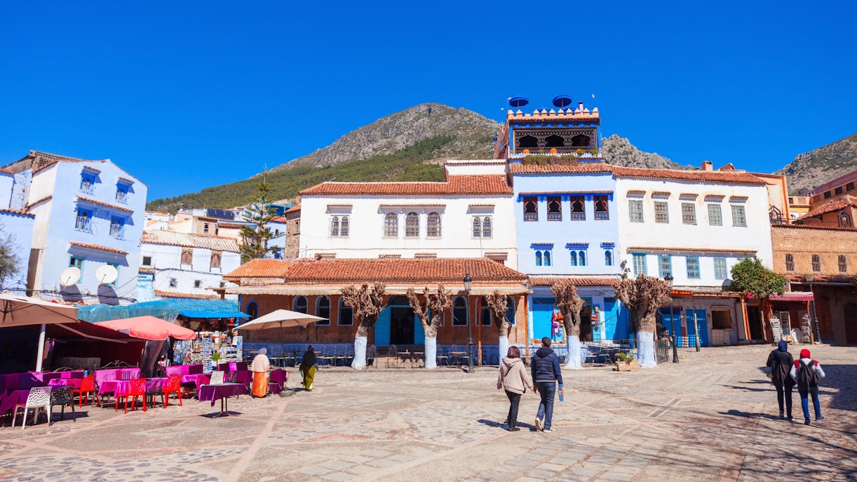Tourists walking through the blue streets of Chefchaouen, Morocco.