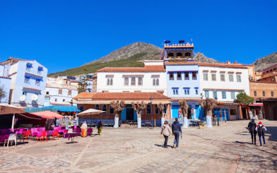 Tourists walking through the blue streets of Chefchaouen, Morocco.