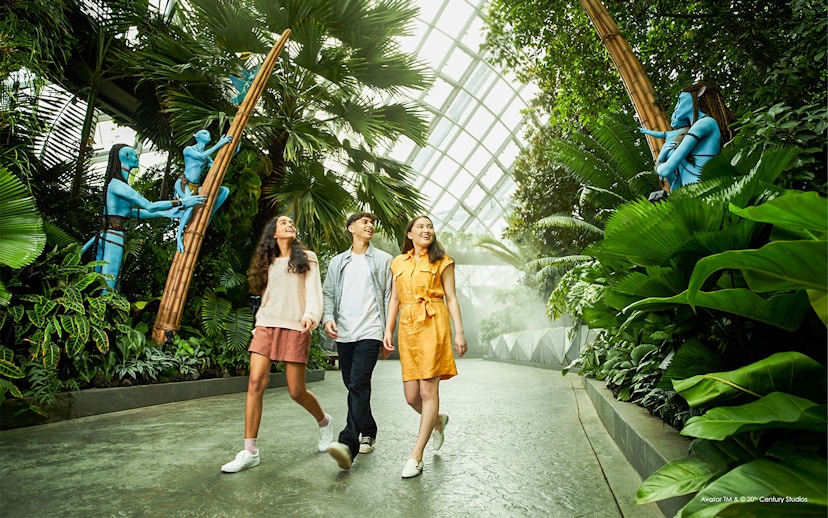 Tourists walking through Gardens by the Bay with Avatar-themed sculptures.