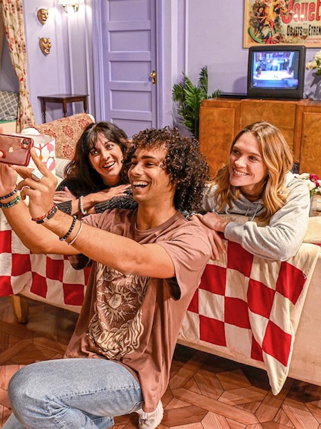 Group taking selfie on iconic Friends set couch at The FRIENDS™ Experience.