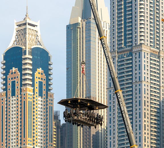 Dinner in the Sky experience suspended by crane with Dubai skyscrapers in the background.