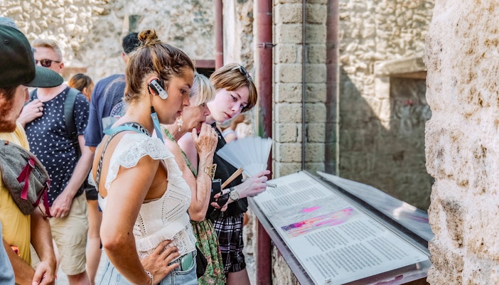 Tourists reading the information about the ruins of Pompeii, Naples