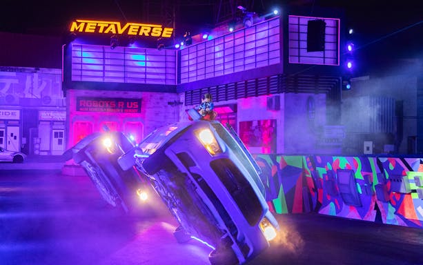 Car performing a stunt on two wheels at Global Village stunt show.
