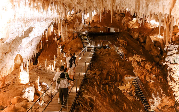 Visitors exploring stalactites and stalagmites in Jewel Cave, Margaret River guided tour.