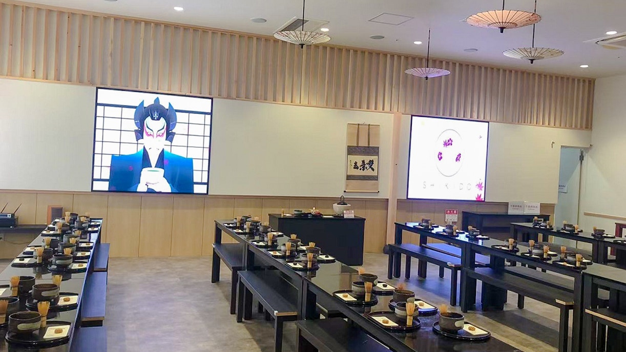 Matcha making class setup with tables, bowls, and whisks in a Japanese-style room.