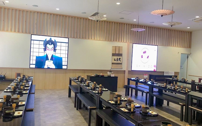 Matcha making class setup with tables, bowls, and whisks in a Japanese-style room.