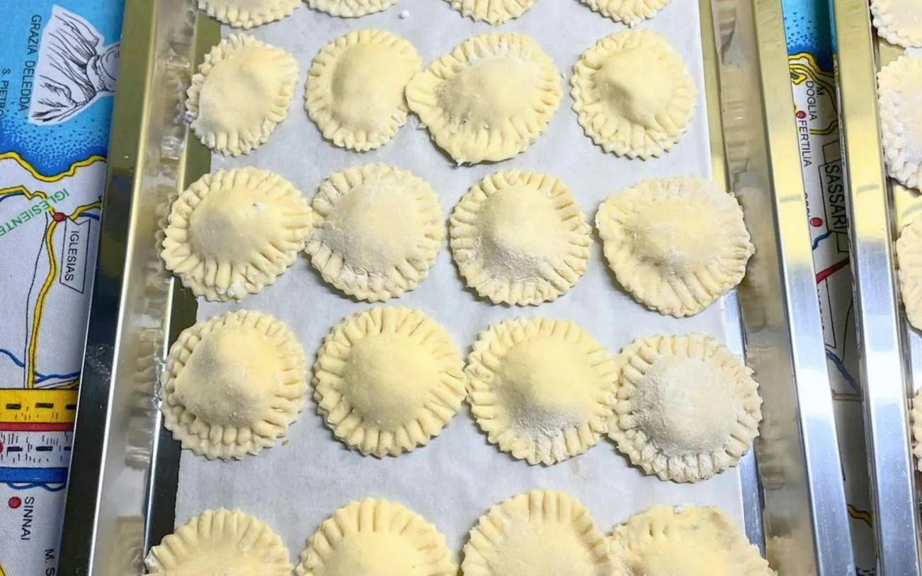 Homemade Sardinian ravioli on a tray during a cooking class in Cagliari.