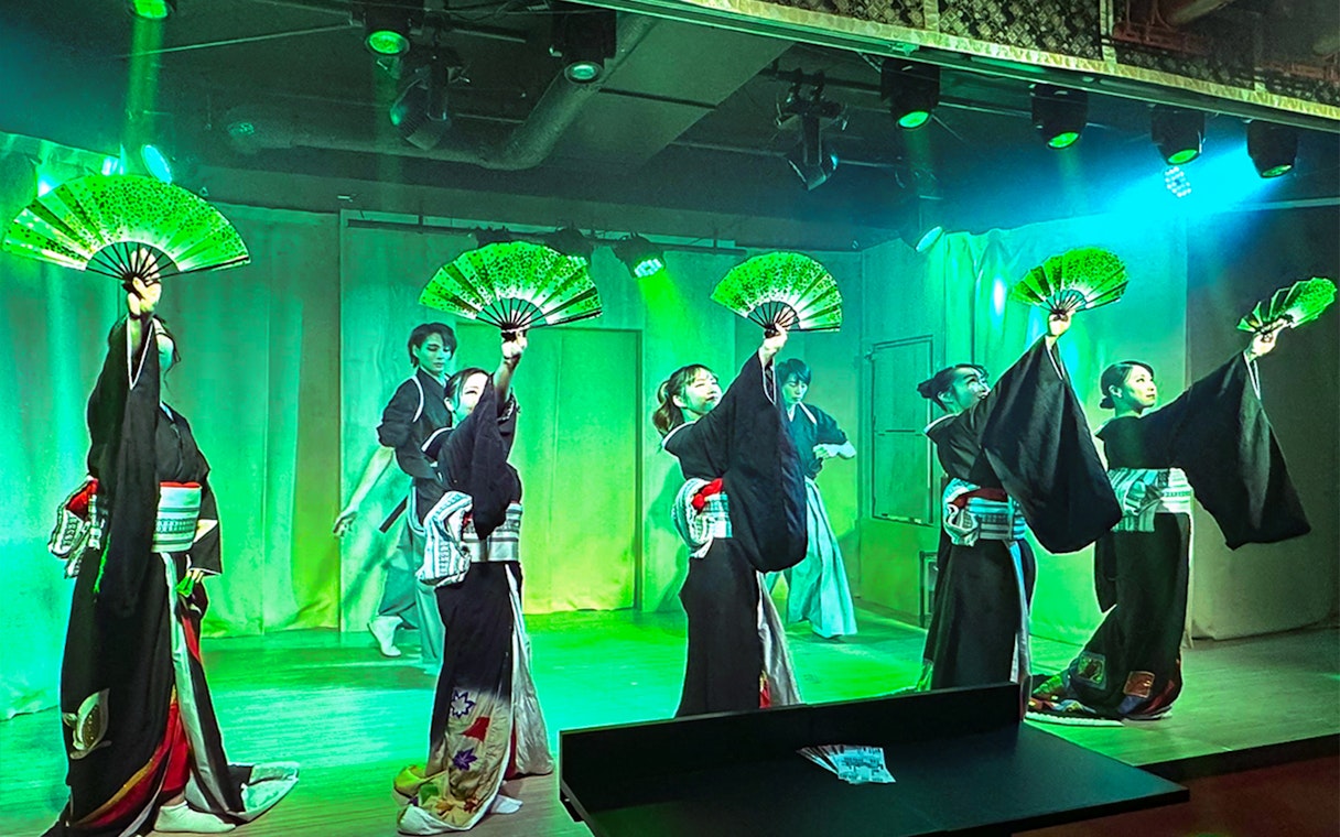 Performers in traditional attire with fans at a Japanese cabaret theatre in Tokyo.
