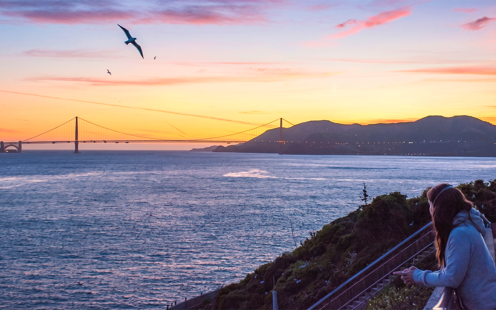 Golden Gate Bridge at sunset viewed from Alcatraz Island during night tour.