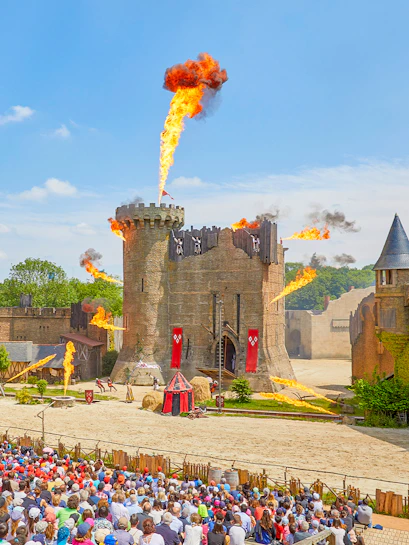 Medieval castle show with fire effects at Puy du Fou, France.