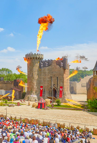 Medieval castle show with fire effects at Puy du Fou, France.