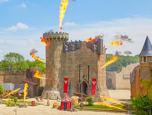 Medieval castle show with fire effects at Puy du Fou, France.